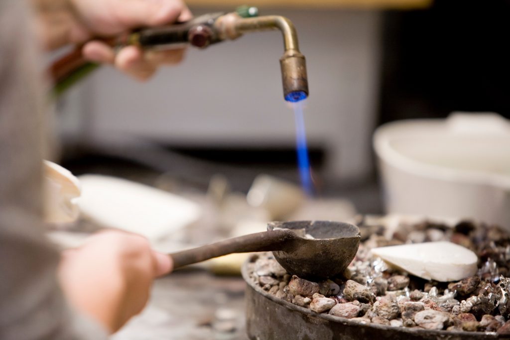 Art students use a torch to liquefy metal in a crucible prior to pouring it into a cast during a metals class at the Mosse Humanities Building at the University of Wisconsin-Madison.