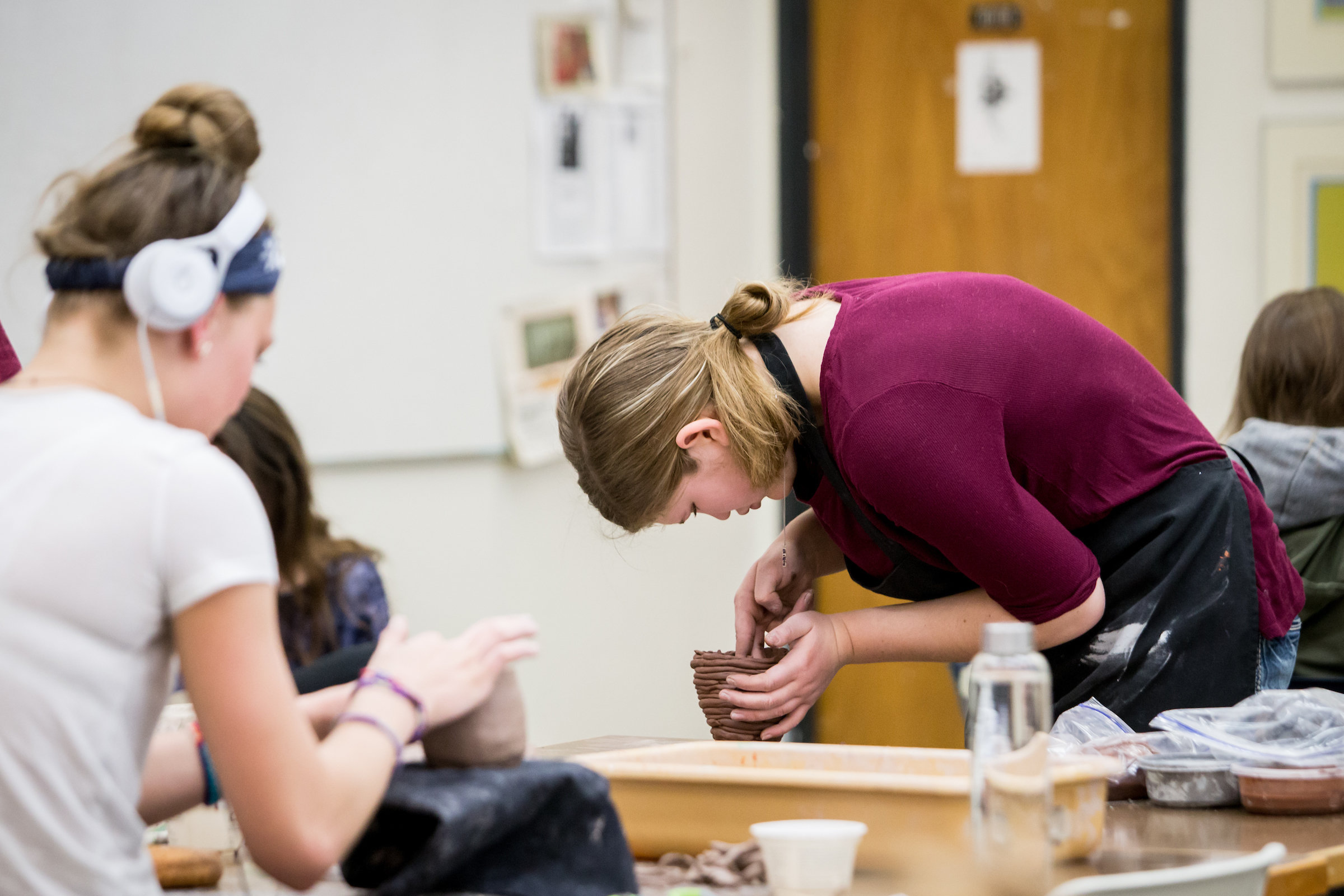 Photo of a VAC student working on a ceramic sculpture.