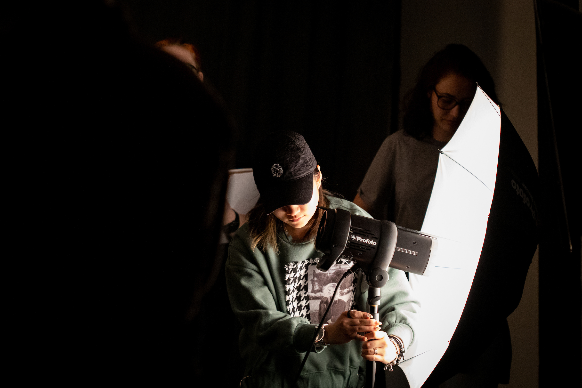 A student adjusts the lighting for a photo shoot in the Lighting Studio at the University of Wisconsin–Madison.